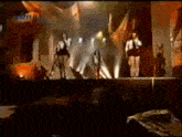 a group of people are dancing on a stage in front of an audience .