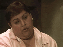 a close up of a woman wearing a pink shirt