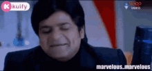 a man in a black suit is making a funny face with his eyes closed