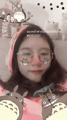 a girl wearing glasses and a scarf has a totoro sticker on her face