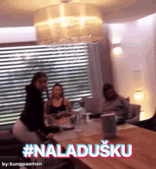 a group of people sitting around a table with the words #naladusku written on the bottom