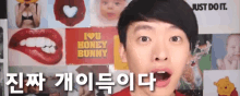 a man is standing in front of a wall with posters on it including one that says i love honey bunny
