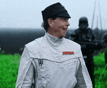 a man in a star wars uniform is smiling in front of a field