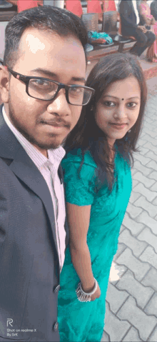 a man and a woman are posing for a picture with the letters r on the bottom right