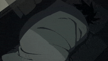 a person wrapped in a blanket is laying on a bed in the dark