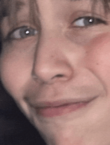 a close up of a person 's face with their eyes closed and a smile on their face .