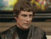 a man wearing a black turtleneck and a black leather jacket