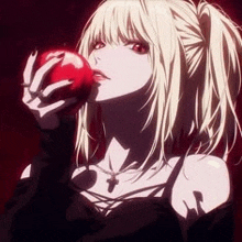 a girl in a black dress is holding a red apple in her hand .