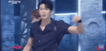a man in a black shirt is dancing on stage .