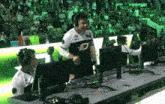 a man wearing a black and white jersey with the letter d on it stands in front of a crowd