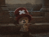 a stuffed animal wearing a red hat with an x on it
