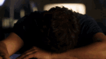 a man with a beard is laying down with his head resting on his arms