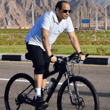 a man wearing sunglasses is riding a bicycle on a street