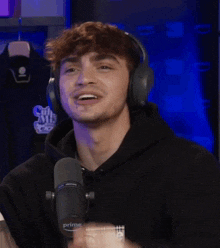 a man wearing headphones and a black hoodie with the word prime on it