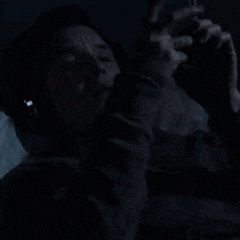 a person wearing headphones is looking at a cell phone in the dark