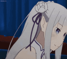 a girl with white hair and purple eyes is sitting on a couch