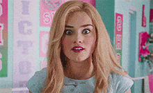 a woman with blonde hair is making a funny face in front of a sign that says ' ice cream ' on it .