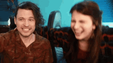a man and a woman are smiling and laughing with their eyes closed