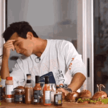 a man wearing a shirt that says ' star ' on it sits at a table surrounded by food