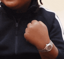 a person wearing a watch on their wrist which shows the time as 10:08