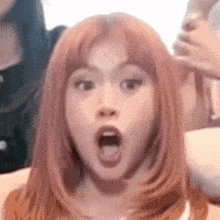 a close up of a woman 's face with a surprised look on her face .