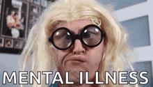 a man wearing glasses and a blonde wig is making a funny face and the words mental illness are behind him .