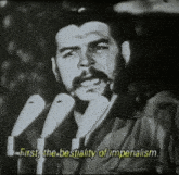 a man speaking into a microphone with the words " first the bestiality of imperialism " below him