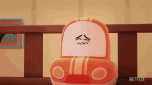 a toy car with a face drawn on it sits on a wooden railing with a netflix logo in the corner