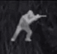 a blurred image of a man holding a gun in a field .