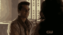 a man and a woman are looking at each other and the letters cw are on the bottom of the screen