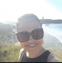 a woman wearing sunglasses smiles for the camera
