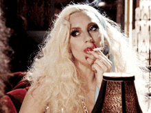 a woman with blonde hair smoking a cigarette
