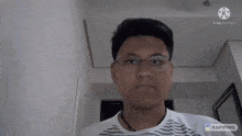 a man wearing glasses and a white shirt is looking at the camera .