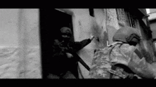 a black and white photo of two soldiers standing next to each other in a room .