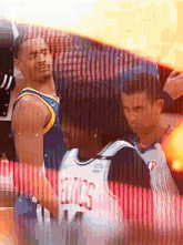 a basketball player wearing a jersey that says fitcs stands next to another player