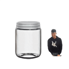 a man wearing a black shirt with a bird on it stands next to a clear jar