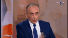 a man in a suit and tie is talking on a television screen