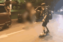 a person riding a skateboard down a street with a car in the background
