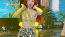 a woman with red hair is singing into a microphone while wearing a yellow top