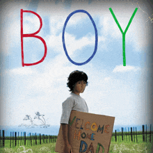 a boy holding a cardboard sign that reads welcome home dad