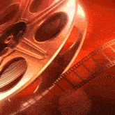 a close up of a film reel with film coming out of it on a red background