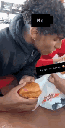 a man is eating a chicken sandwich with a sticker that says me on it .