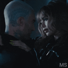 a man and a woman are looking at each other with the letters ms visible
