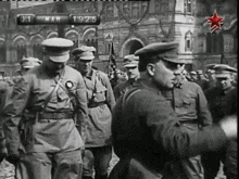a black and white photo of soldiers marching in front of a sign that says march 19 1915