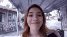 a woman is sitting in a golf cart smiling at the camera .