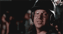 a man in a helmet and goggles is holding a sparkler in his mouth .