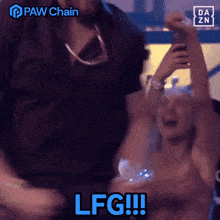 a man and woman are celebrating with paw chain written in blue