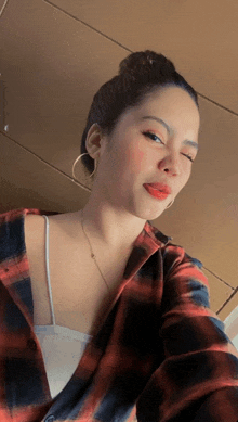 a woman in a plaid shirt takes a selfie