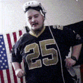 a man wearing a number 25 jersey is standing in front of an american flag
