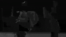 a black and white photo of a person in a dark room with a blurred background .